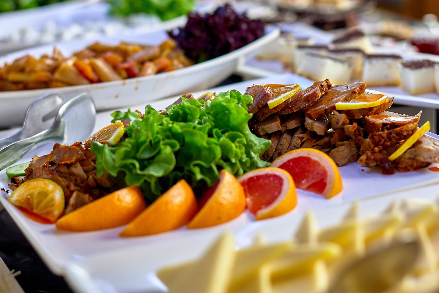 Buffet self-service com carne assada, salada e laranja no balcão da Hot & Cold